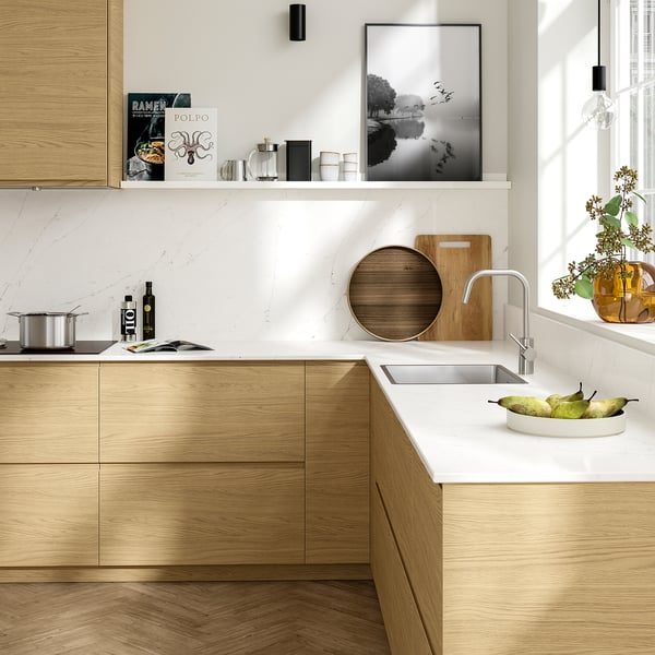 Modern wood kitchen with white counter and built-in sink. Minimalist design, recycled glass top, undermount sink, wooden shelves.