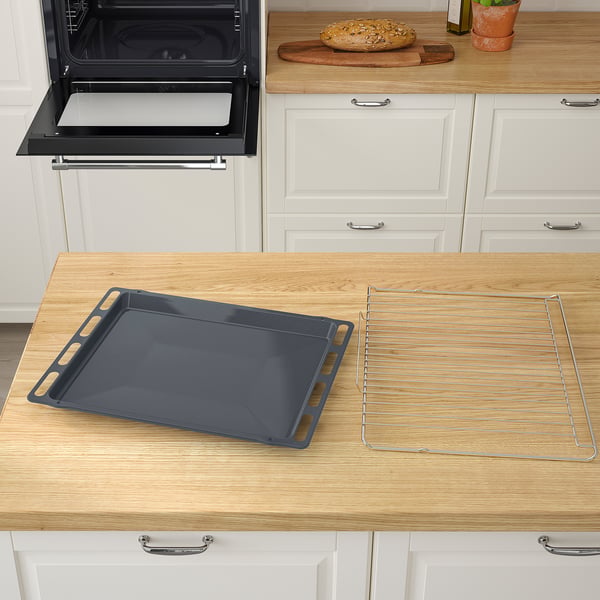This kitchen scene shows a MATTRADITION oven with an open door, revealing an empty oven tray and wire rack, ready for baking.