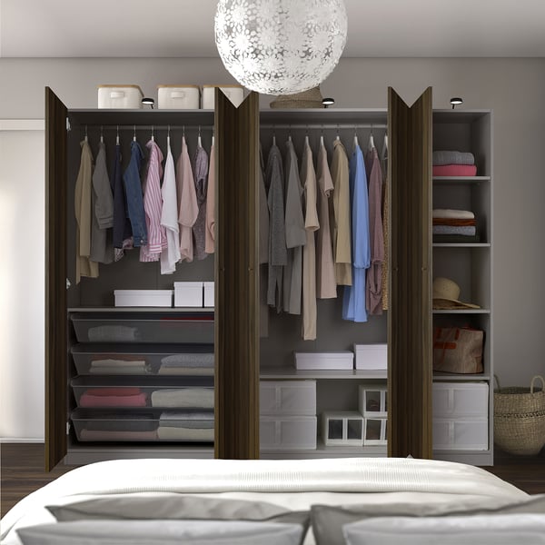 Organised wardrobe with clothes on hangers, folded items in shelves and mesh baskets.