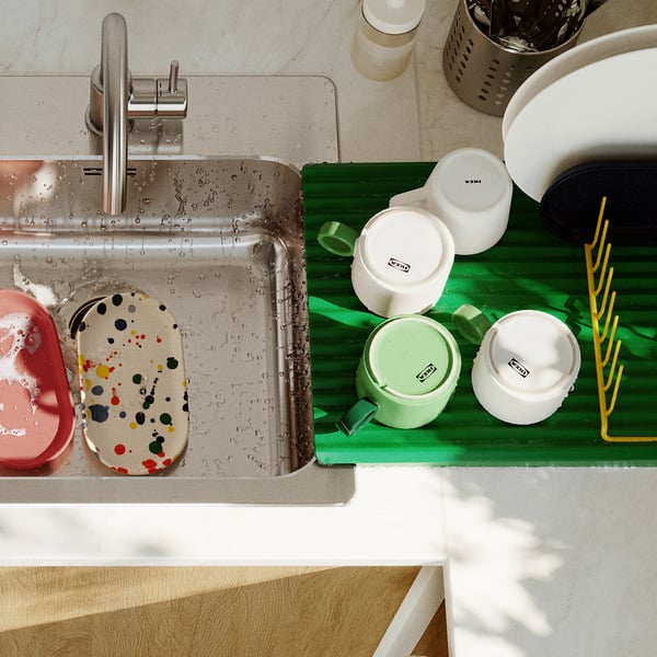 Bubbly dishes in sink, green plate holder dries 9 plates, brightens kitchen.