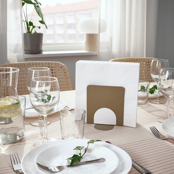 Table set with SKOGSRÖR, plates, glasses, chairs, greenery, napkins prepped.