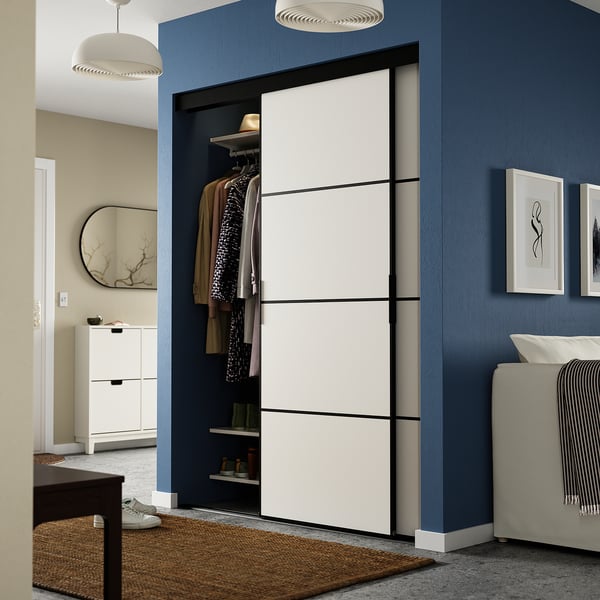 Modern bedroom with large SKYTTA wardrobe, bed, mirror, and shoe cabinet.