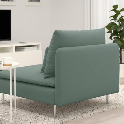 Modern green SÖDERHAMN sofa with deep seats and loose cushions, near a small table with a coffee cup.