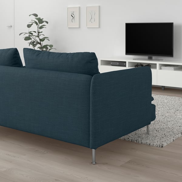 Modern living room with dark blue SÖDERHAMN sofa, white walls, tv, and plant.
