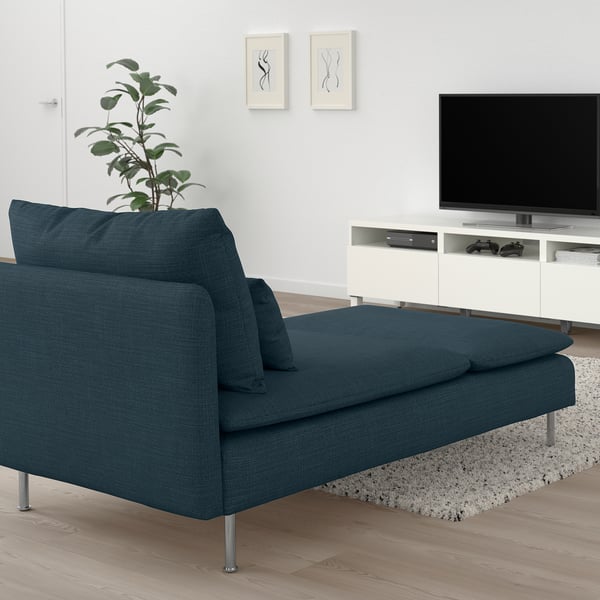 Blue chaise longue next to tv stand with cushions. Ideal for relaxation with a modern design.