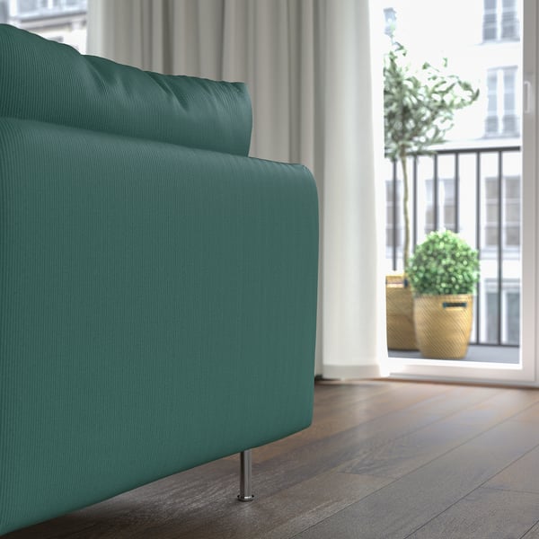 Teal SÖDERHAMN chaise lounge. Soft, padded comfort for deep sitting, ideal for relaxation or reading. Near window with city view.