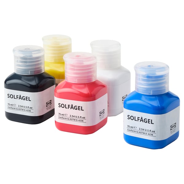Five colorful ikea SOLFÅGEL paint bottles: yellow, red, blue, white, black.