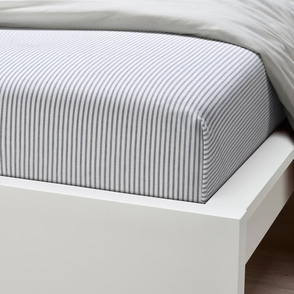 Crisp, gray-striped cotton bedsheet on white bed, showcasing soft texture and quality stitching.