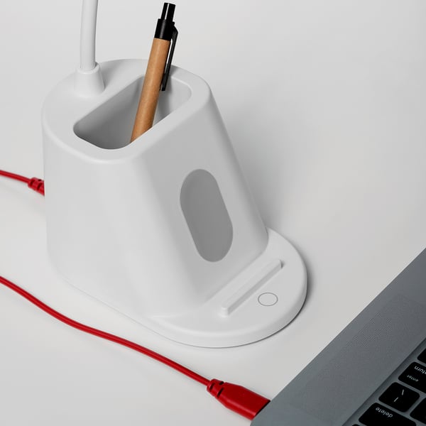 A white, adjustable desk lamp with pen holder, featuring variable touch dimmer and usb charging capability.