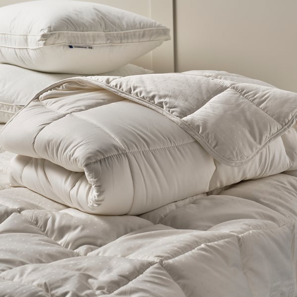 White STRANDMOLKE duvet, soft cotton, plush filling, neat fold.