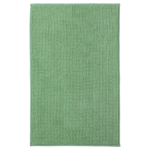 A TOFTBO mint green bath mat. Its rectangular, soft, and made from recycled polyester. Its textured surface is designed for quick drying.