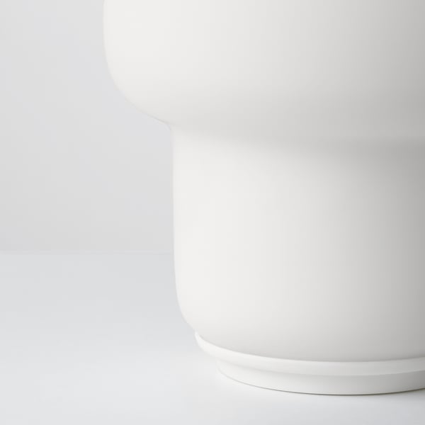 Small white table lamp with sleek glass shade sits perfectly on any shelving or table top. Its design offers a minimalist yet elegant appeal.