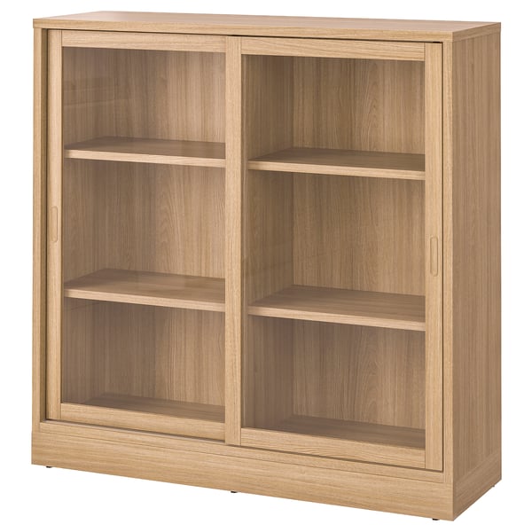 A TONSTAD light brown wooden bookshelf with sliding glass doors and adjustable shelves.