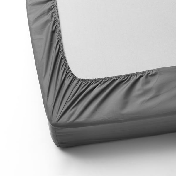 Grey fitted sheet with elastic edges covering a white mattress, showcasing its smooth and soft texture.