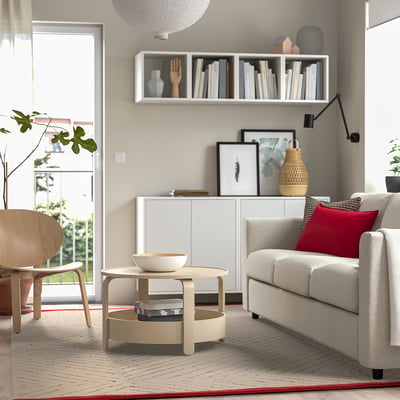 Modern living room with UNDERVISNING rug, patterned, under coffee table, near sofa, against wall with shelves.