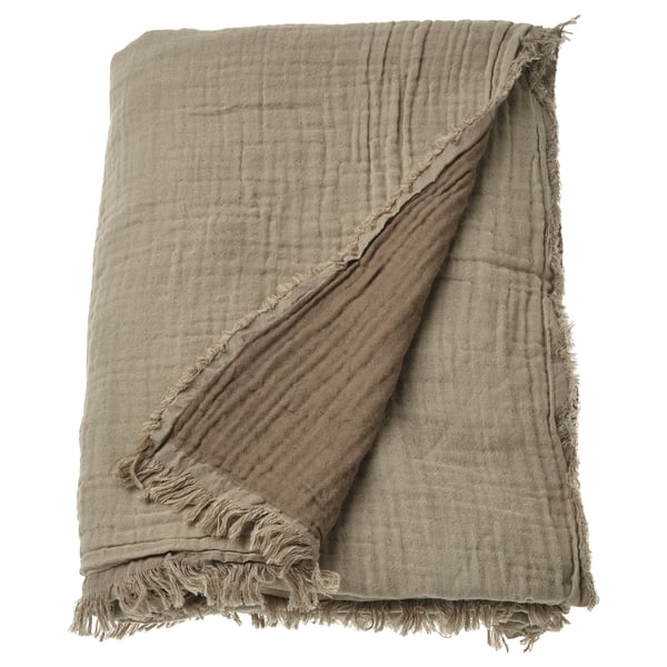 VALLKRASSING beige cotton throw; textured, fringed edges, draped.