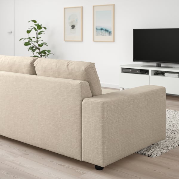 A VIMLE beige sofa-bed in minimalist living room with tv.
