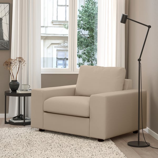 The VIMLE sofa, beige, modern minimalist design, medium size for living rooms. It a tall black floor lamp.