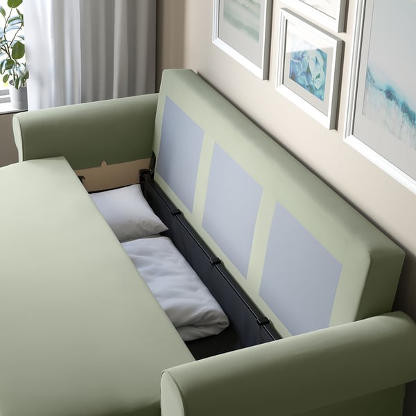 Modern sofa-bed with storage, partially open to reveal pillow inside. Perfect for quick sleep setup and space-saving.