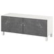 A white BESTÅ tv bench with two gray marble-patterned doors and square legs. It offers storage and cable management for a tidy space.