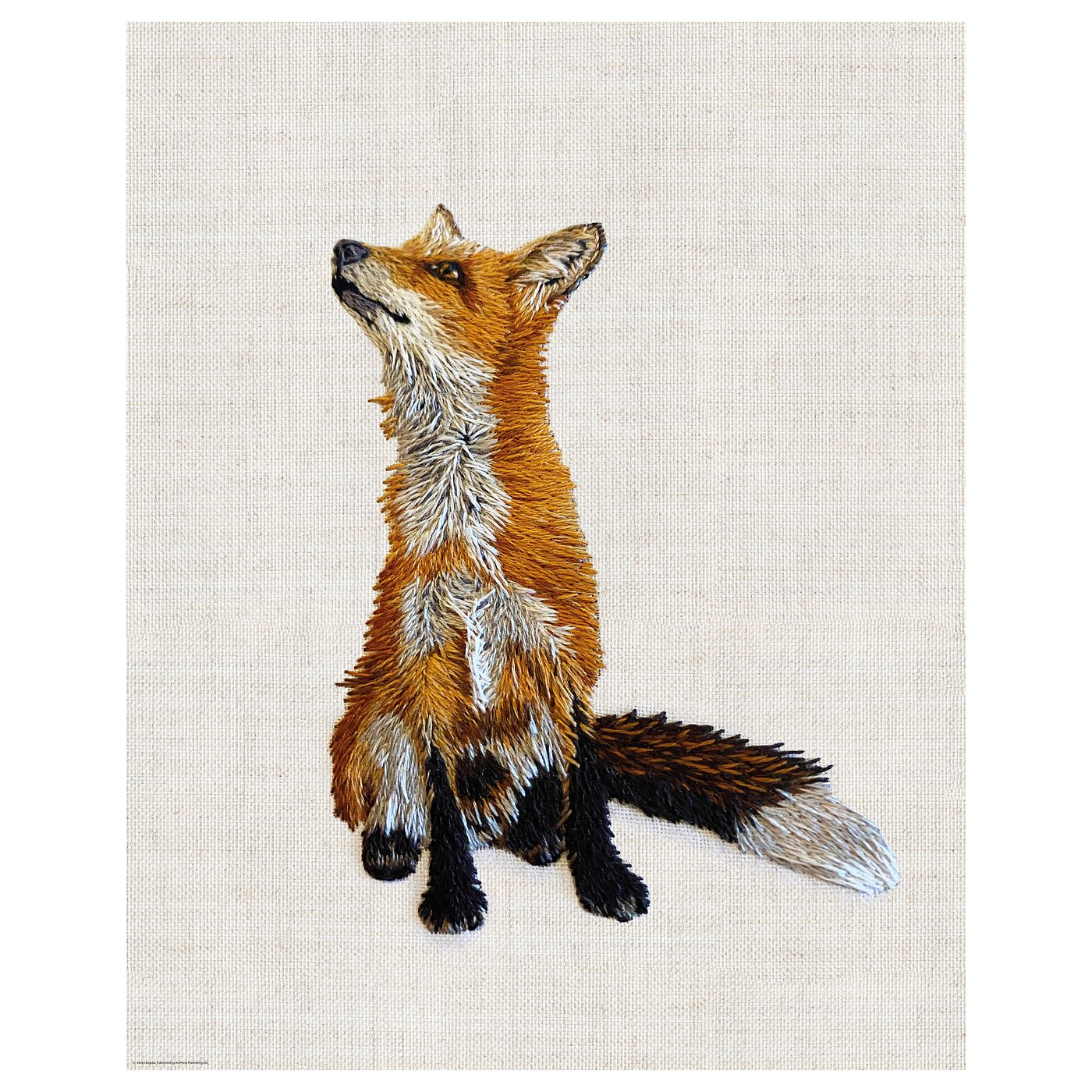 Embroidered fox on beige cloth, sitting with raised paws, detailed stitching.
