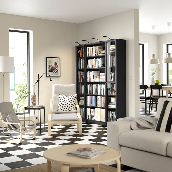 Modern living room with BILLY black bookcase, white furniture, chequered floor, large window, and pendant lights.