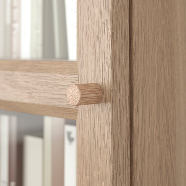 Wooden cabinet with modern, cylindrical handle, showcasing quality craftsmanship and natural texture.