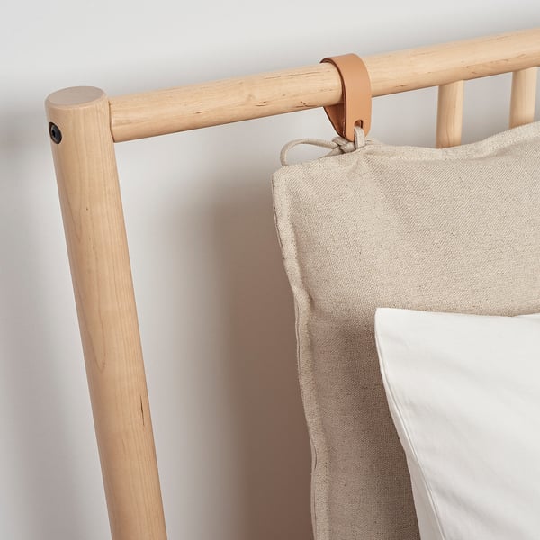 Minimalist wooden headboard with beige pillow, sleek design, natural finish.