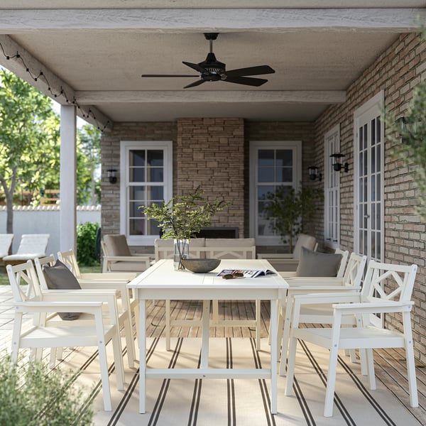 BONDHOLMEN outdoor dining set: white acacia table & 8 chairs with cushions on porch.