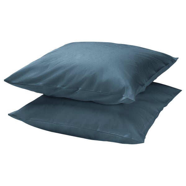 Two stacked teal-colored square pillows, smooth texture, simple design.