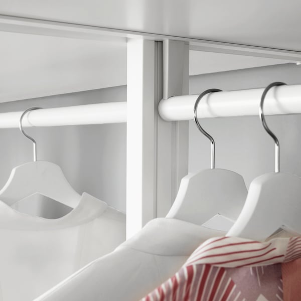 Clean, modern closet with adjustable shelves and hangers, showing white hangers and a striped shirt.