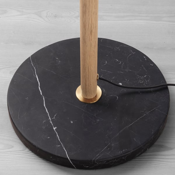 Round dark marble base, wooden pole, brass accent, quality materials.