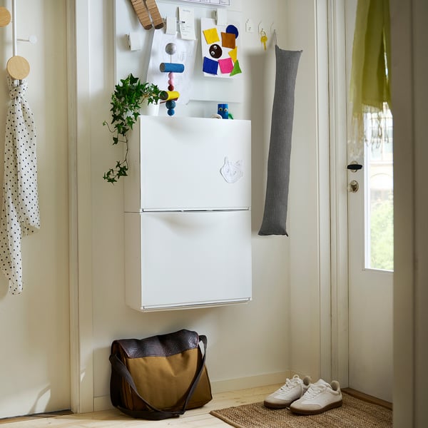 Small white FAGEBLÅMME cushion cover with grey ties on wall near fridge.