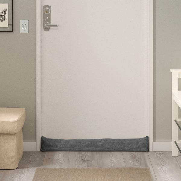 Grey FAGEBLÅMME draught excluder, recycled polyester, fits under door.
