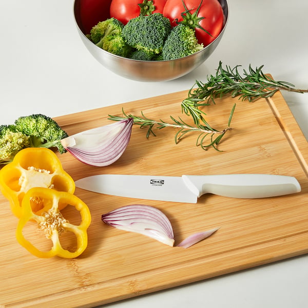 Wooden cutting board with fresh veggies and HACKIG knife.