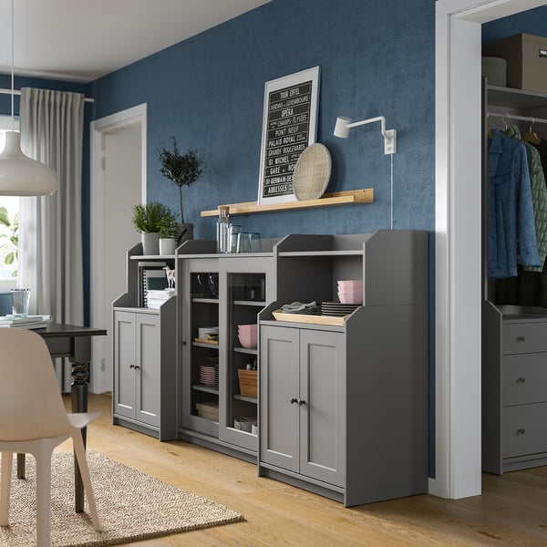 Modern kitchen with grey HAUGA cabinets, wooden floors, blue walls, and plants.