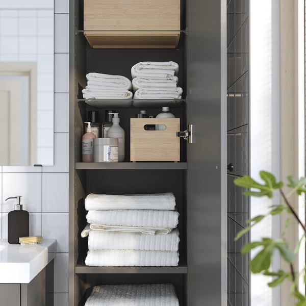 Contemporary bathroom cabinet, HAVBÄCK, with towels and toiletries, saves space and hides items, mounted high.