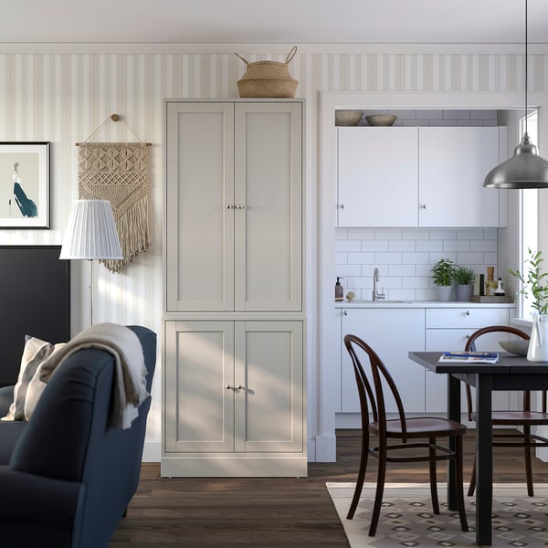 Living room with grey HAVSTA cabinet, blue chair, fireplace, kitchen.