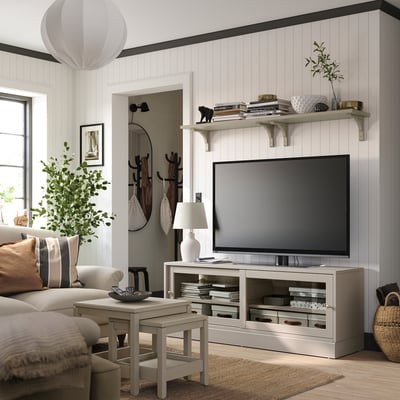 Modern living room with HAVSTA tv stand, light wood, open shelves, large screen tv, cosy couch, side table, floor lamp, and potted plant.