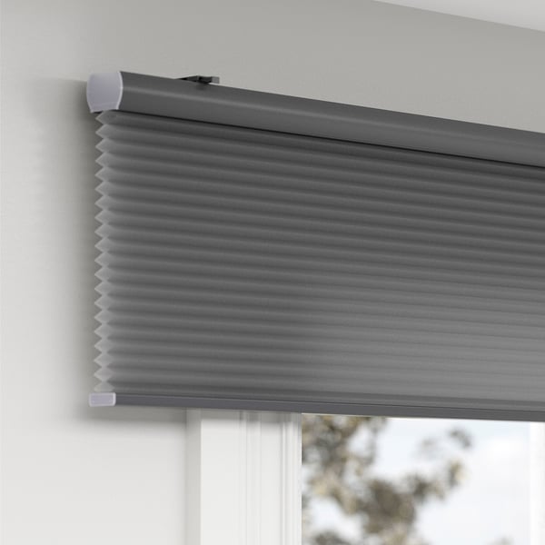 Grey room-darkening cellular blind with hidden cord, mounted on wall, providing privacy and insulation.