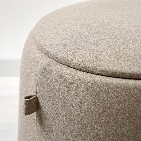 Round ottoman with smooth, padded top and curved sides.
