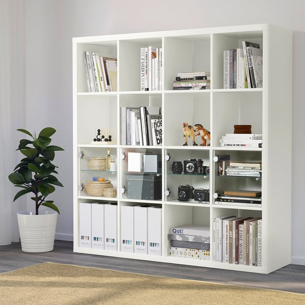 White KALLAX shelf with books, plants, decor.