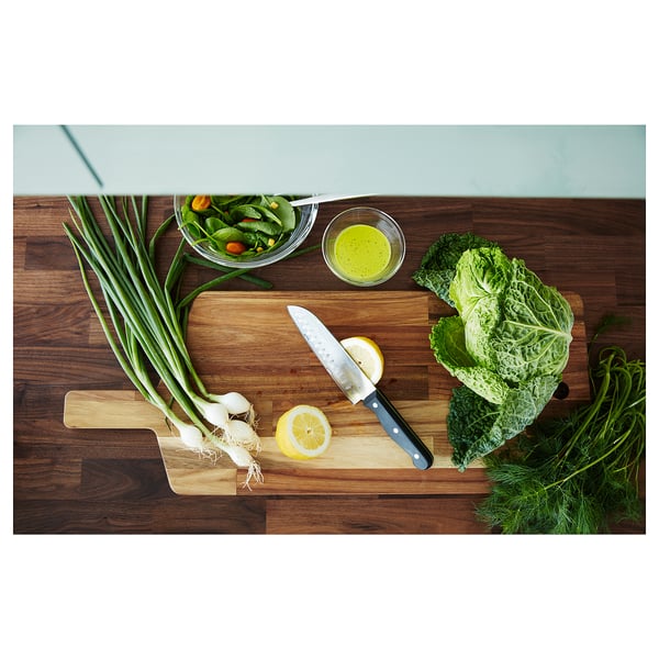 Wood prep area with knife, veggies, lemon on brown KARLBY counter.