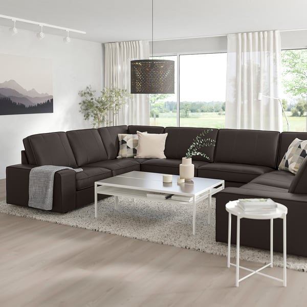 Modern living room with large l-shaped KIVIK dark grey sofa, white coffee table, and large window. Clean & cosy design.