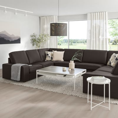 Modern living room with large l-shaped KIVIK dark grey sofa, white coffee table, and large window. Clean & cosy design.