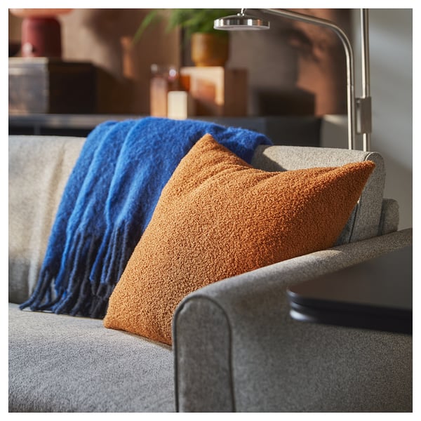 Grey sofa with soft brown and blue throw pillows.