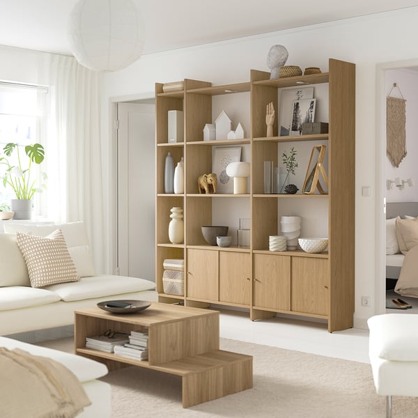Modern living room with LÅDMAKARE shelves, white vases, sofa, coffee table, pillow, and plant.