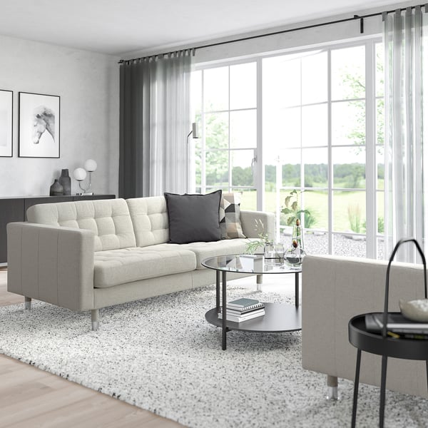Modern living room with LANDSKRONA sofa, coffee table, and large windows. Sleek, minimalist design.
