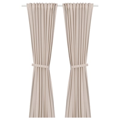 Two light pink cotton curtains with ribbed texture and tie-backs hang side by side, creating a formal and dressed-up feel.