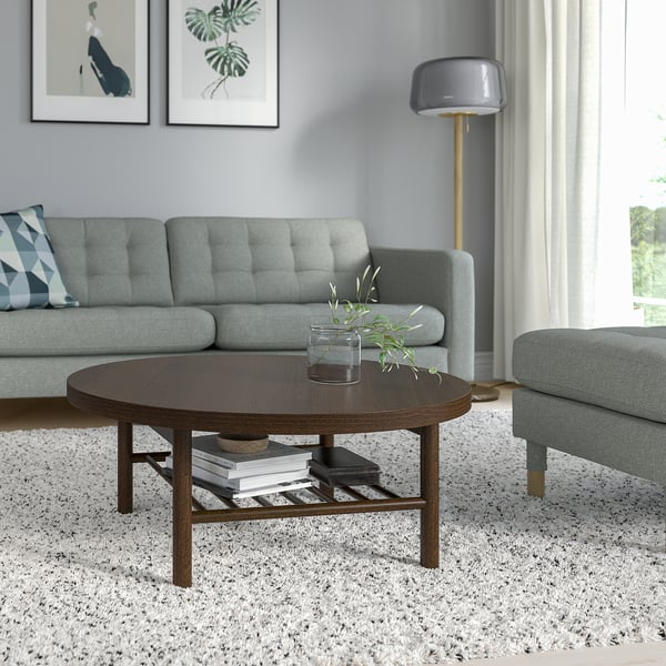 Modern living room with LISTERBY coffee table, books, plant, blue sofa, lamp, artwork.
